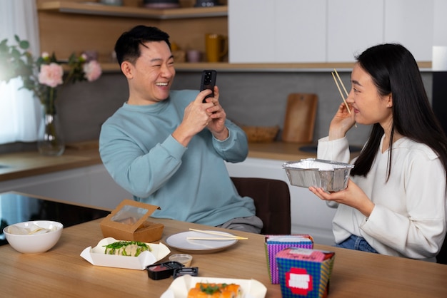 アジア料理を食べるミディアムショットの人々