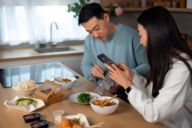 アジア料理を食べるミディアムショットの人々