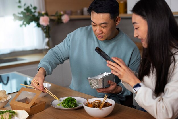 아시아 음식을 먹는 중간 샷 사람들