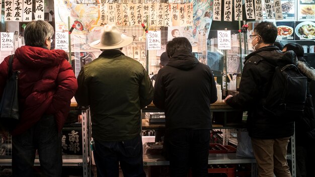 Люди среднего размера едят в ресторане японской уличной еды
