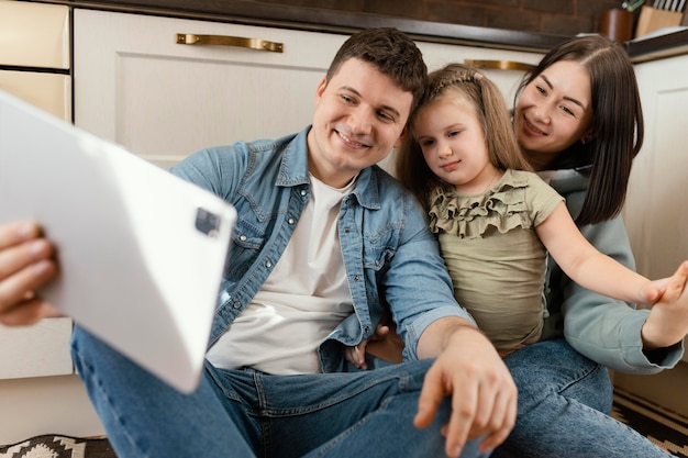 Medium shot people on floor with tablet