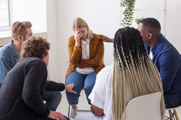 Medium shot people helping sad woman