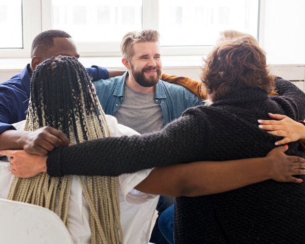 Medium shot people hugging at meeting