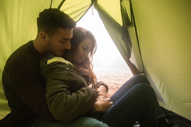 Free photo medium shot people hugging in tent