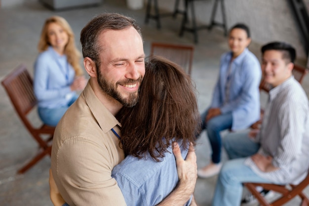 Medium shot people hugging in therapy