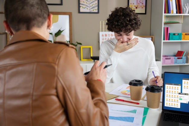 Foto gratuita persone di tiro medio che ridono al lavoro