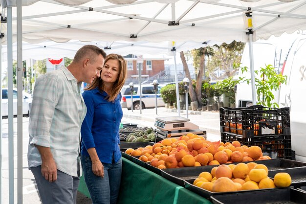 Medium shot people looking at fruits