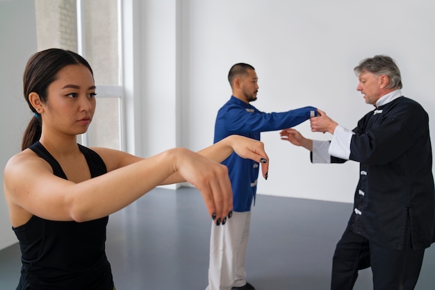 Medium shot people practicing tai chi