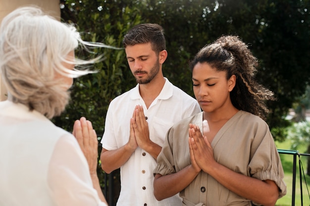 Free photo medium shot people praying together