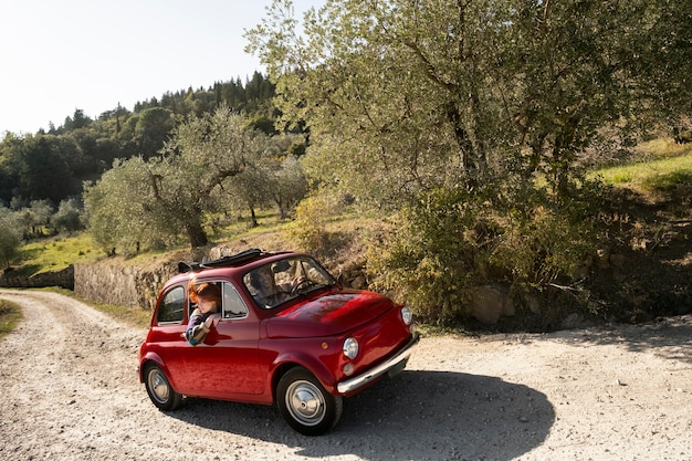 Medium shot people in red car