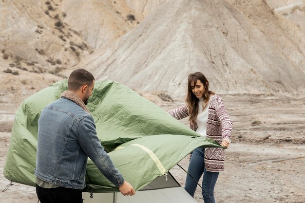 Medium shot people setting up a tent