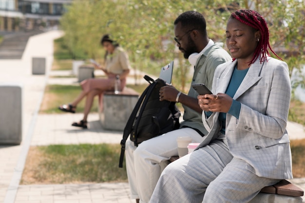 Medium shot people sitting on bench