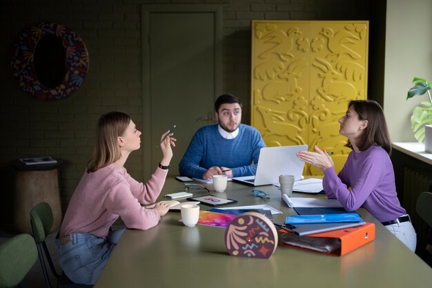 Persone di tiro medio sedute a tavola