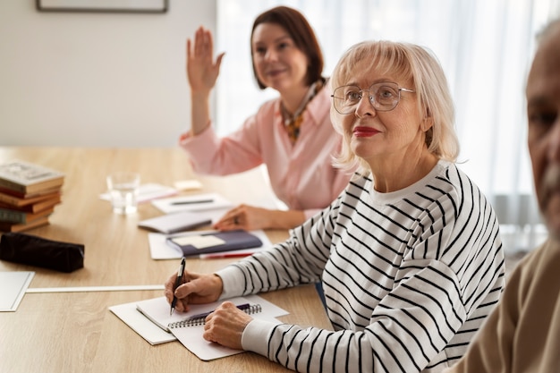 Foto gratuita persone di tiro medio che studiano in classe