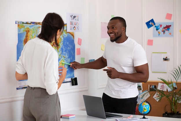 Free photo medium shot people in  travel agency office