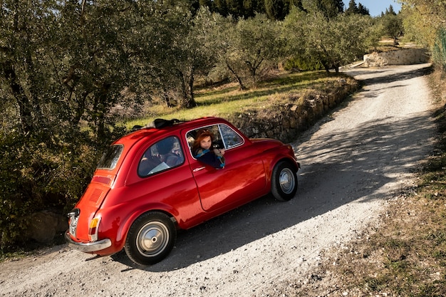 赤い車で旅行するミディアムショットの人々