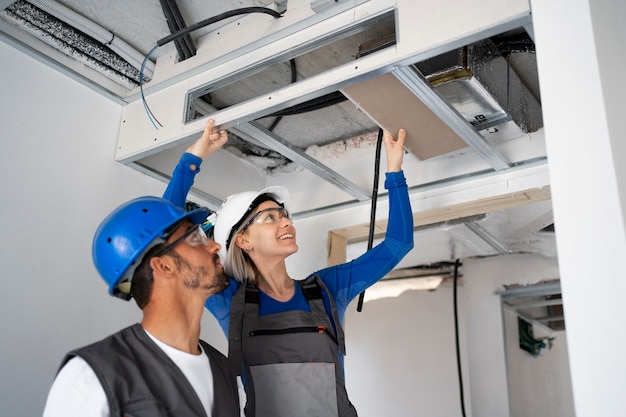 Foto gratuita persone di tiro medio che indossano caschi al lavoro