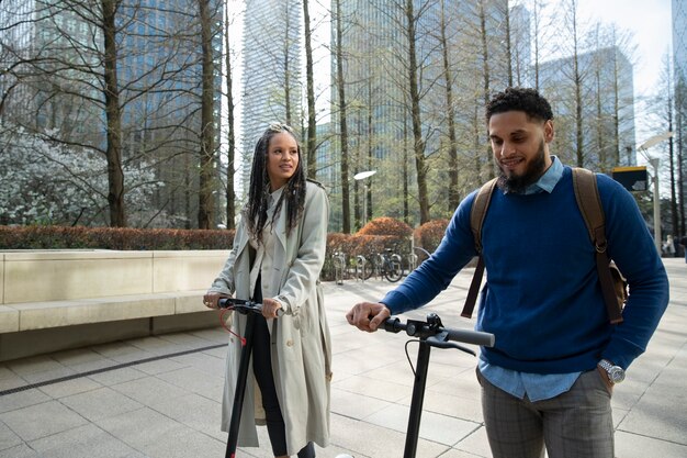 Medium shot people with electric scooters in park