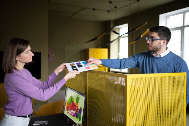 Medium shot people at work holding color palette
