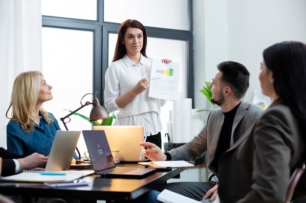 Medium shot people working together at office