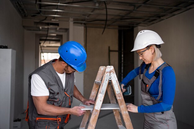 Free photo medium shot people working with ladder