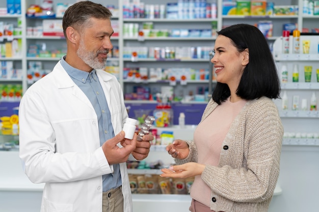 Foto gratuita farmacista di tiro medio che aiuta il paziente