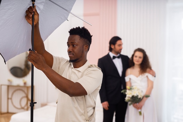 Foto gratuita fotografo di medie riprese e coppia di sposi