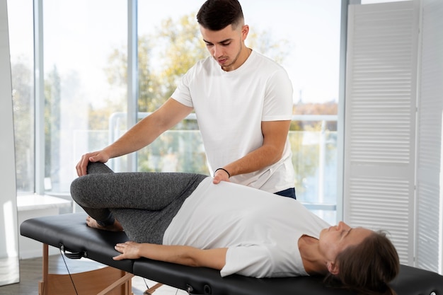 Medium shot physiotherapist helping woman