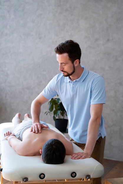 Medium shot physiotherapist massaging boy