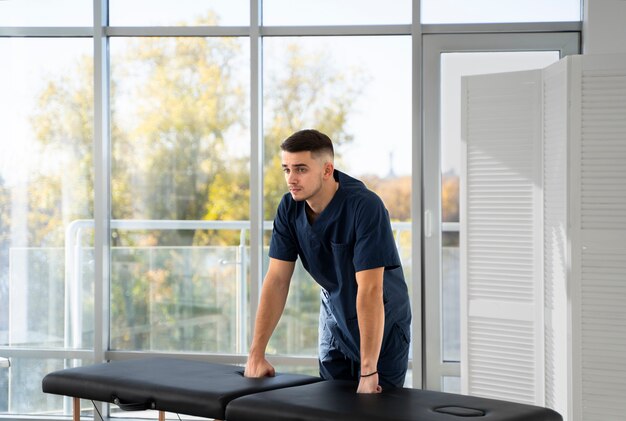 Medium shot physiotherapist with table