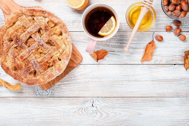 Medium shot of pie with tea and honey