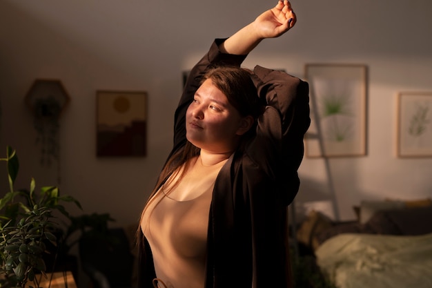 Medium shot plus-sized woman stretching