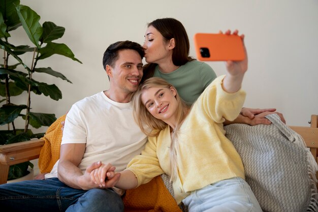 Medium shot polyamorous partners taking selfie