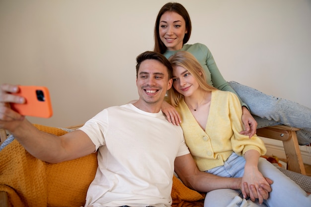 Medium shot polyamorous partners taking selfie