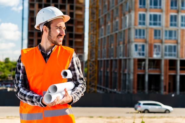 Medium shot portrait of engineer holding plans