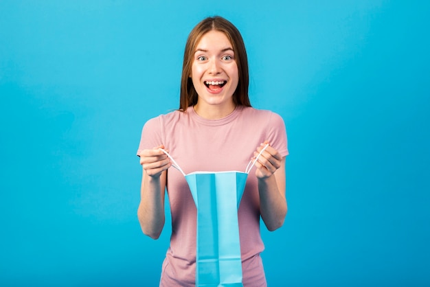 Medium-shot portrait of a happy woman holding a shopping bag 