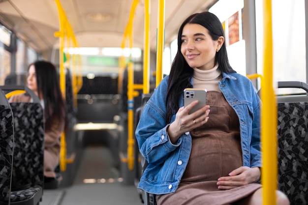 Средний снимок беременной женщины в автобусе