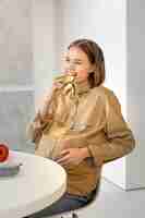 Free photo medium shot pregnant woman eating fruit