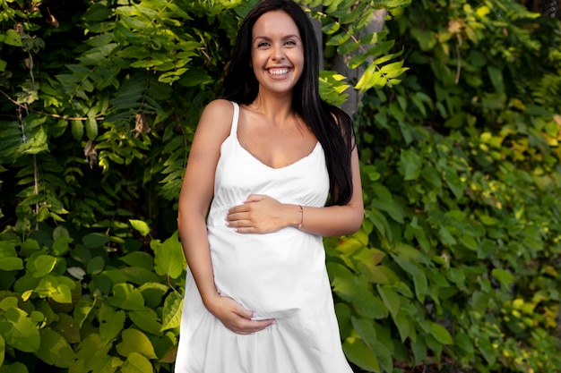Средний снимок беременной женщины, держащей живот