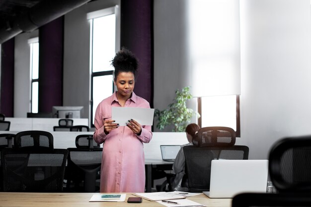 Medium shot pregnant woman holding document