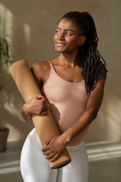 Free photo medium shot pregnant woman holding yoga mat