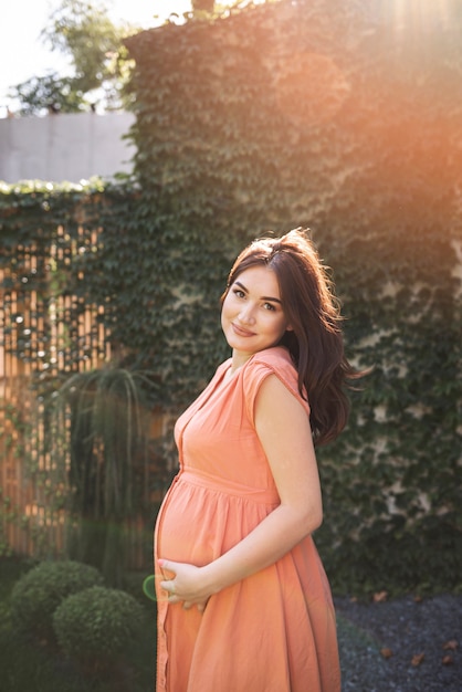 Medium shot pregnant woman posing outdoors