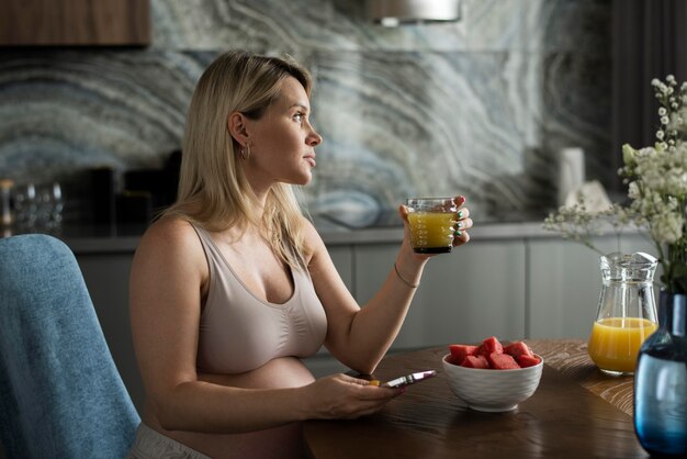 Medium shot pregnant woman with juice