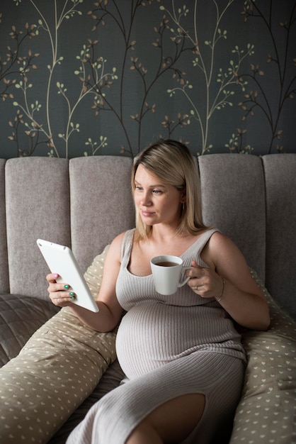 Free photo medium shot pregnant woman with tablet