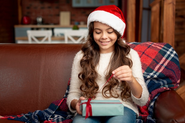 Medium shot pretty girl opening her gift