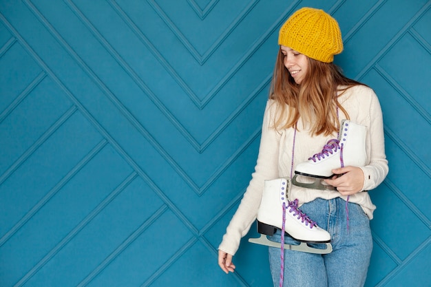 Foto gratuita ragazza graziosa del colpo medio con il cappello giallo e pattini da ghiaccio