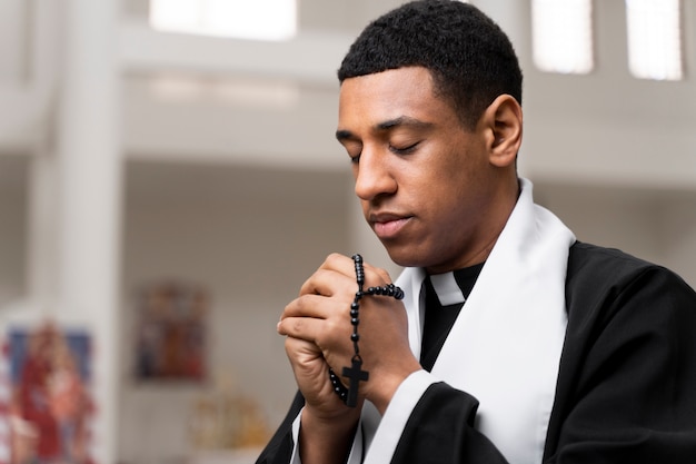 Medium shot priest praying in church