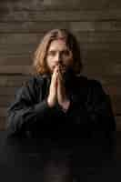 Free photo medium shot priest praying indoors