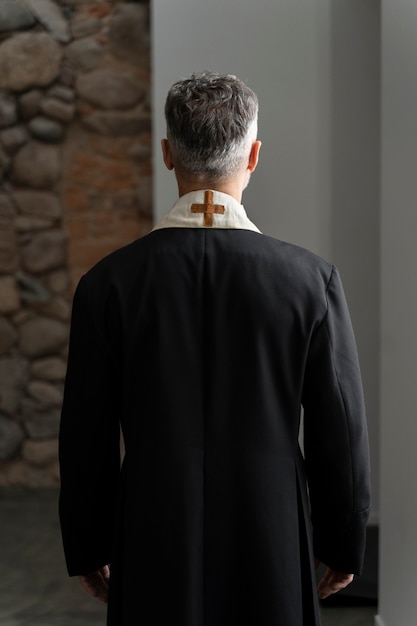 Free photo medium shot priest wearing cassock