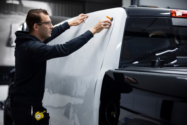 Uomo professionista di tiro medio che avvolge l'auto